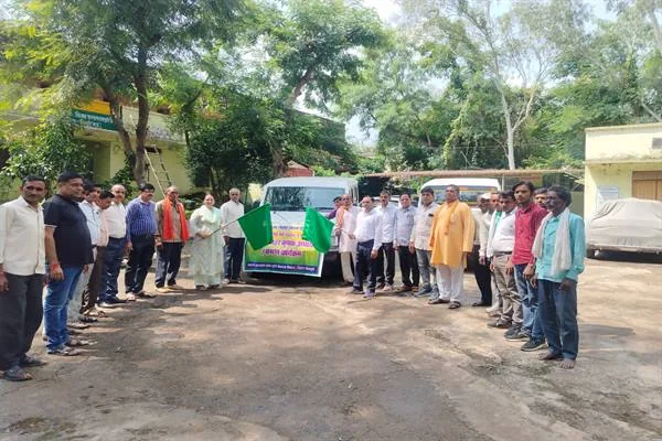 कृषि कार्यालय परिसर में दो वाहनों के सामने हरी झंडी और बैनर के साथ खड़े किसान तथा अधिकारी